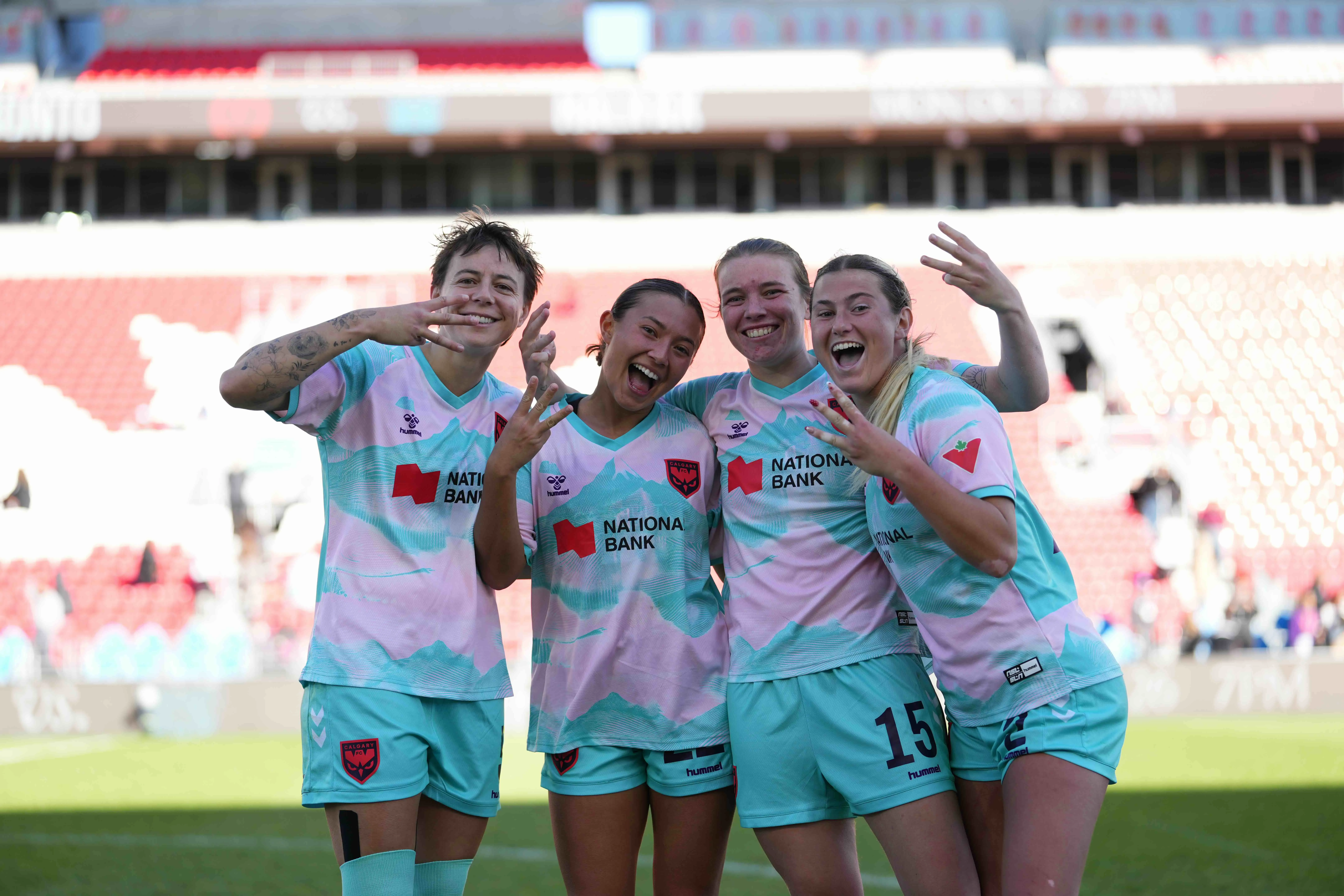Four Calgary Wild FC players celebrate together at BMO Field