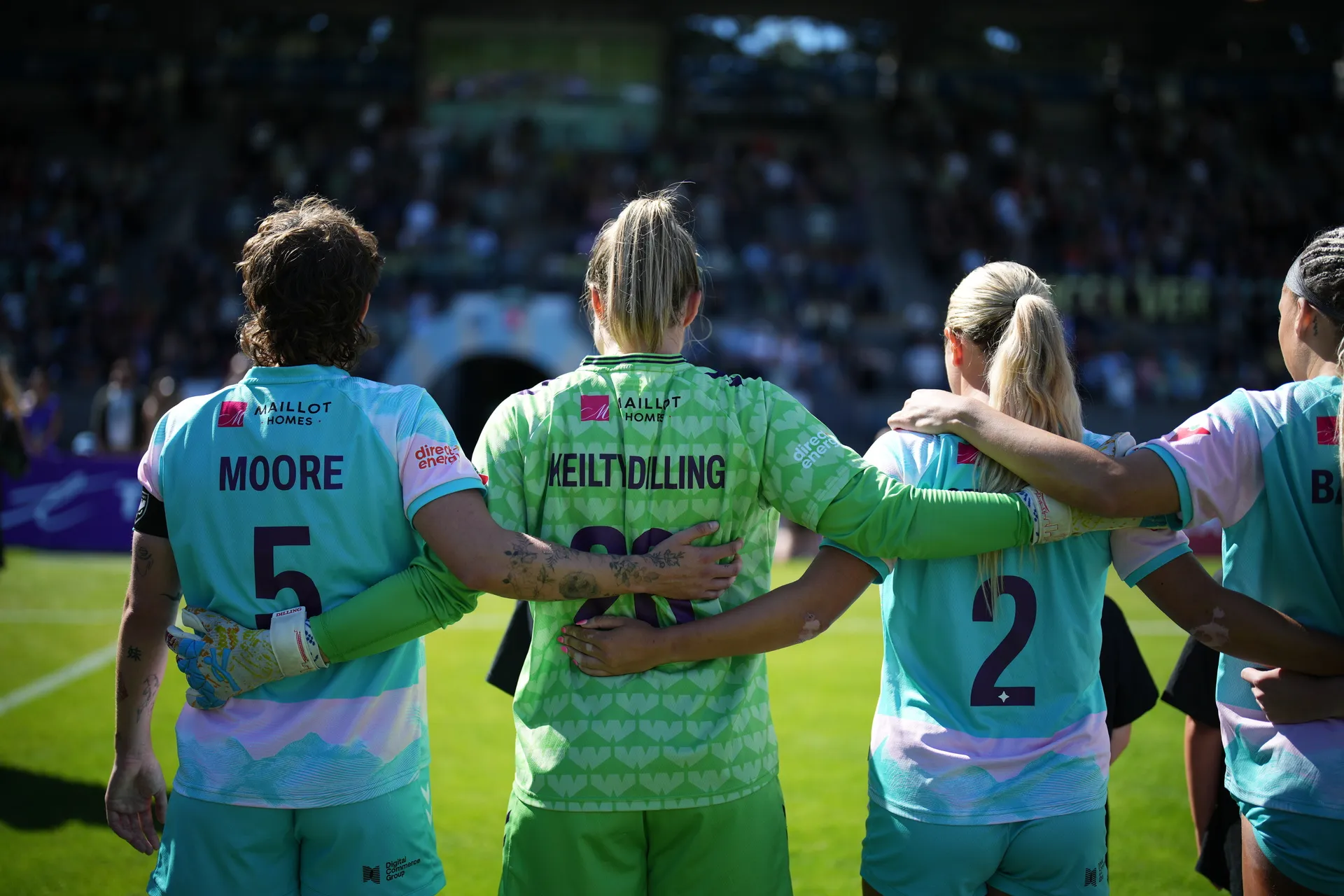 Calgary Wild FC players link arms during match against Vancouver Rise FC