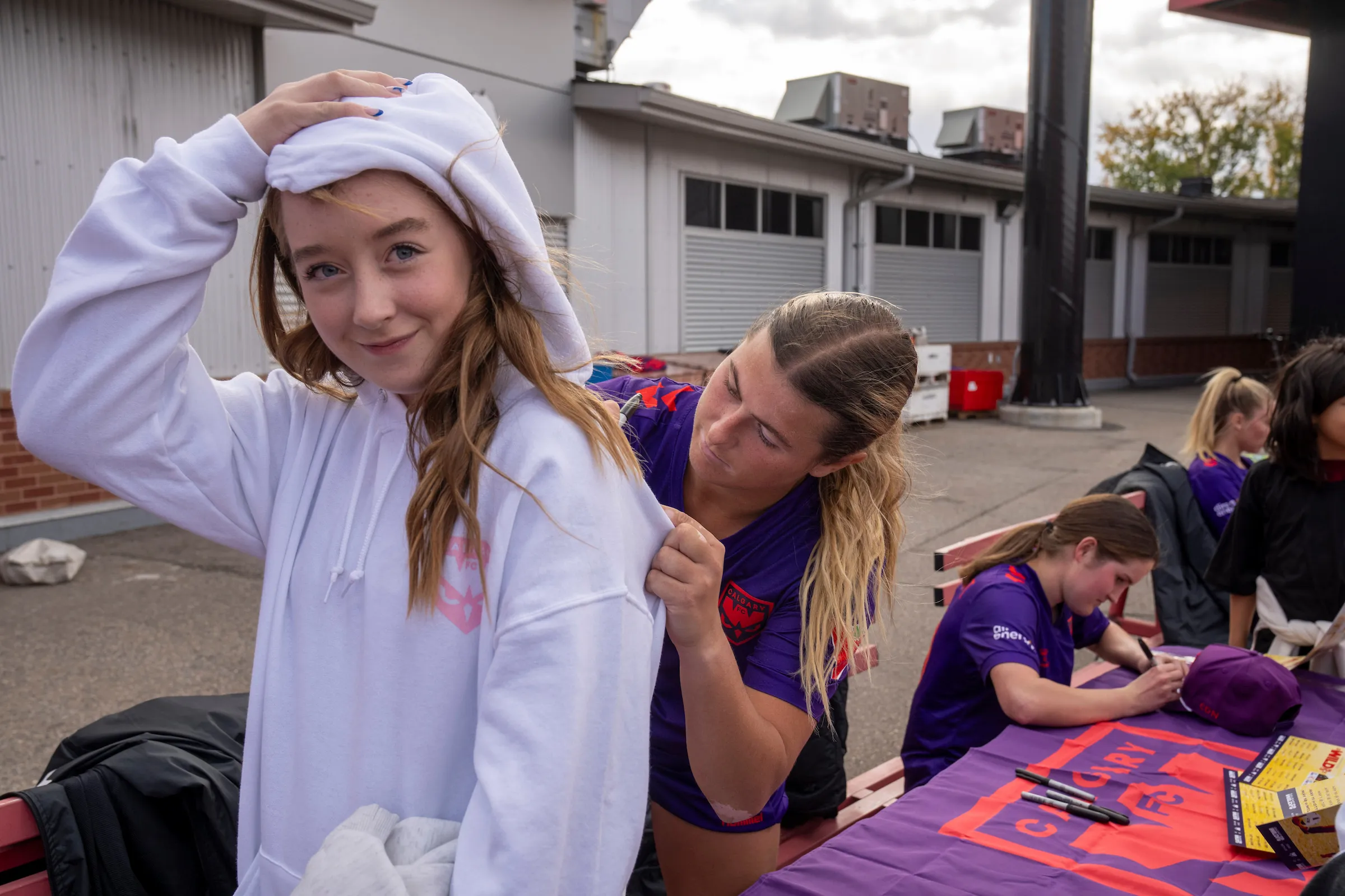 A child signing a onesie at the group ticket experience